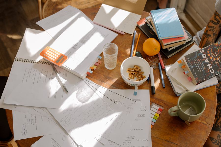 Desk covered with academic papers and study material